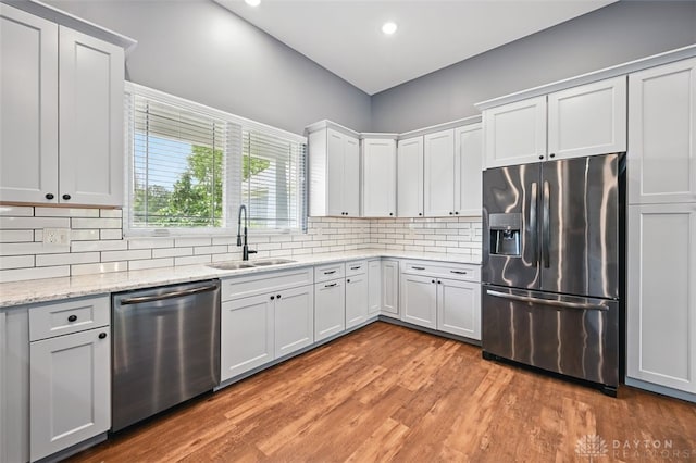 1584 Heritage Run Dr, Lebanon, OH 45036 - kitchen featuring stainless steel appliances, tasteful backsplash, light wood finished floors, recessed lighting, and light stone counters