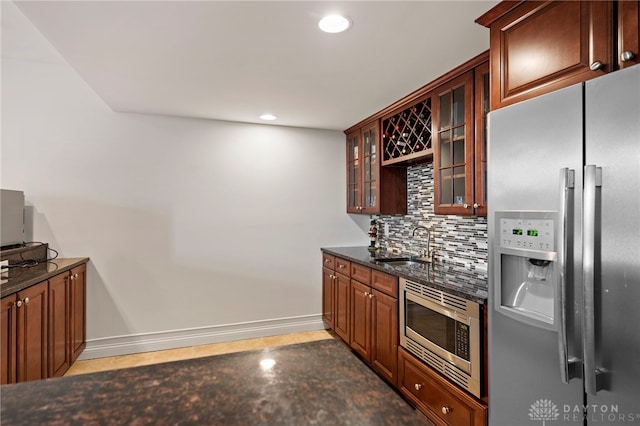 4738 Saddletop Ridge Ln, Mason, OH 45040 - kitchen with appliances with stainless steel finishes, backsplash, glass insert cabinets, recessed lighting, and dark stone counters