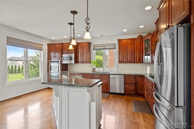 4738 Saddletop Ridge Ln, Mason, OH 45040 - kitchen featuring appliances with stainless steel finishes, light wood-style floors, a kitchen bar, brown cabinets, and recessed lighting