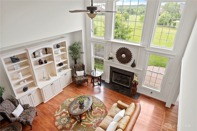 4738 Saddletop Ridge Ln, Mason, OH 45040 - living area featuring a towering ceiling, light wood finished floors, ceiling fan, a fireplace with flush hearth, and built in shelves