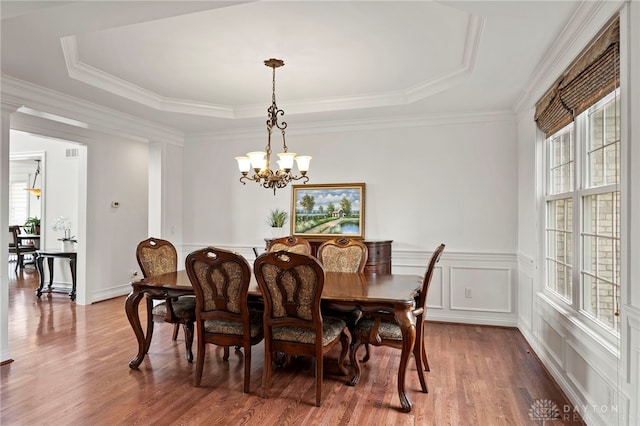 4738 Saddletop Ridge Ln, Mason, OH 45040 - dining space featuring a chandelier, wood finished floors, a raised ceiling, wainscoting, and a decorative wall
