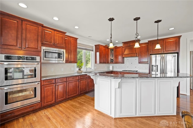 4738 Saddletop Ridge Ln, Mason, OH 45040 - kitchen with stainless steel appliances, a kitchen breakfast bar, dark stone countertops, decorative backsplash, and recessed lighting