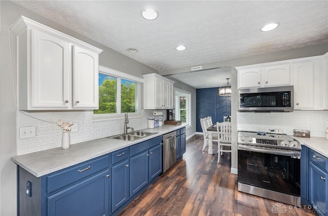 4395 Turtledove Way, Miamisburg, OH 45342 - kitchen featuring appliances with stainless steel finishes, blue cabinetry, white cabinetry, decorative backsplash, and a textured ceiling