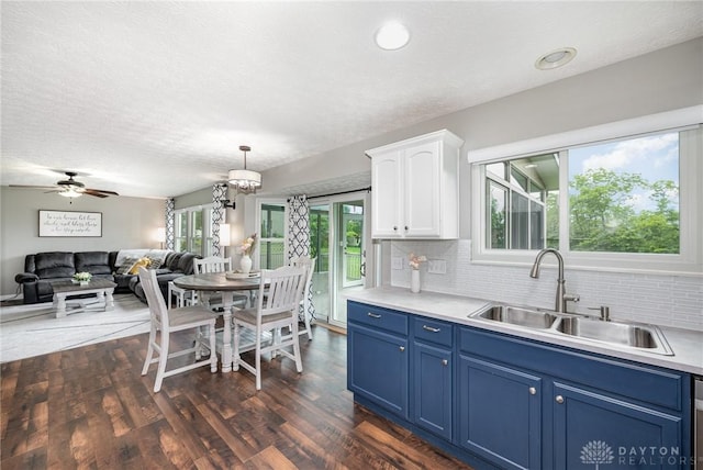 4395 Turtledove Way, Miamisburg, OH 45342 - kitchen with blue cabinets, white cabinets, backsplash, light countertops, and dark wood finished floors