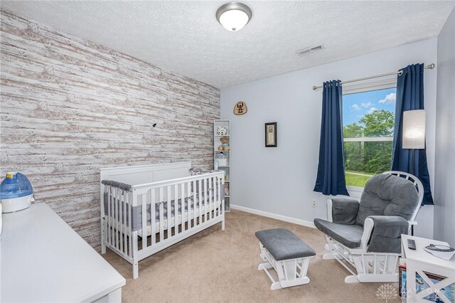 4395 Turtledove Way, Miamisburg, OH 45342 - carpeted bedroom featuring a crib, a textured ceiling, and an accent wall