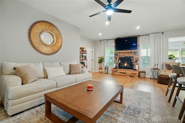 181 Cresting Rd, Fairborn, OH 45324 - living room with wood finished floors, a ceiling fan, a stone fireplace, and recessed lighting