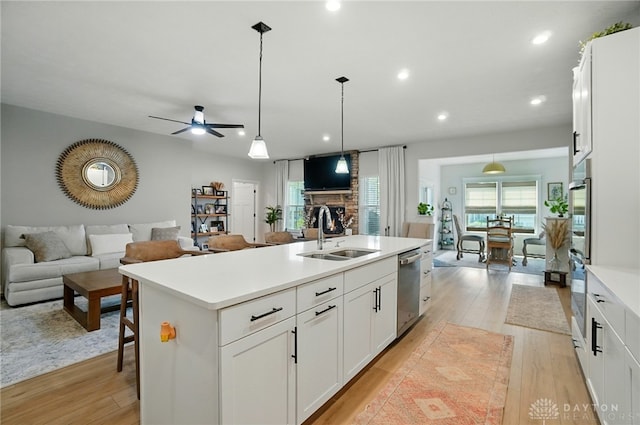 181 Cresting Rd, Fairborn, OH 45324 - kitchen with open floor plan, appliances with stainless steel finishes, a fireplace, a center island with sink, and ceiling fan