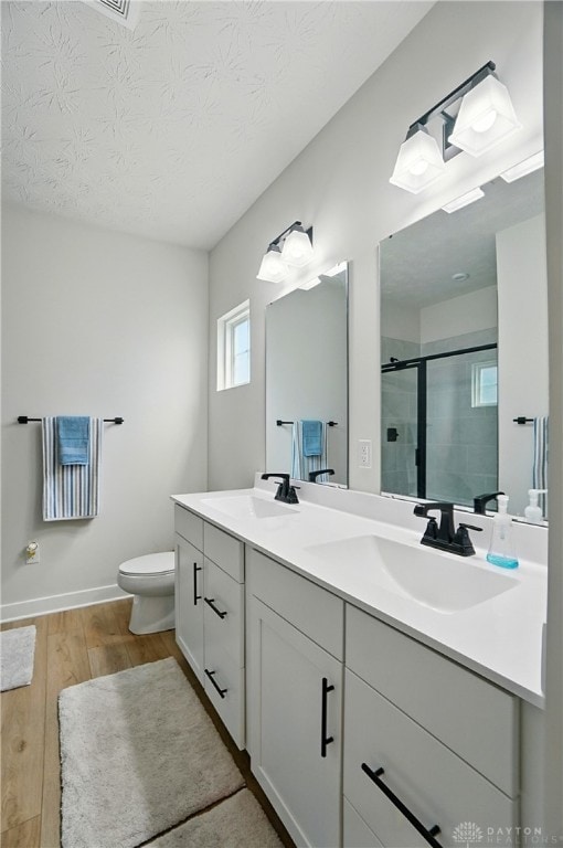 181 Cresting Rd, Fairborn, OH 45324 - bathroom with wood finished floors, double vanity, a shower stall, and a textured ceiling