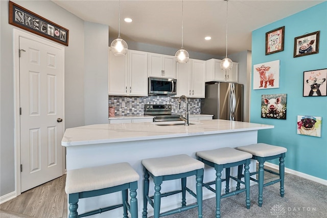 928 Southline Dr, Lebanon, OH 45036 - kitchen with stainless steel appliances, tasteful backsplash, a breakfast bar, white cabinetry, and pendant lighting