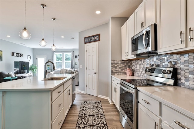 928 Southline Dr, Lebanon, OH 45036 - kitchen with stainless steel appliances, open floor plan, tasteful backsplash, wood finished floors, and a center island with sink