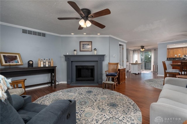 2823 Red Lion Ct, Centerville, OH 45440 - living room featuring ceiling fan, wood finished floors, a fireplace with raised hearth, crown molding, and a textured ceiling