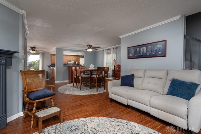 2823 Red Lion Ct, Centerville, OH 45440 - living area featuring a ceiling fan, ornamental molding, a textured ceiling, dark wood-style flooring, and healthy amount of natural light
