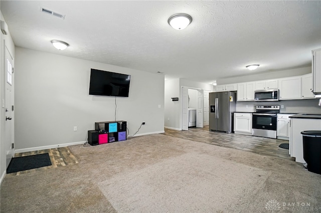 720 Diamond Loop, Middletown, OH 45044 - unfurnished living room with carpet floors, a textured ceiling, and washer / dryer