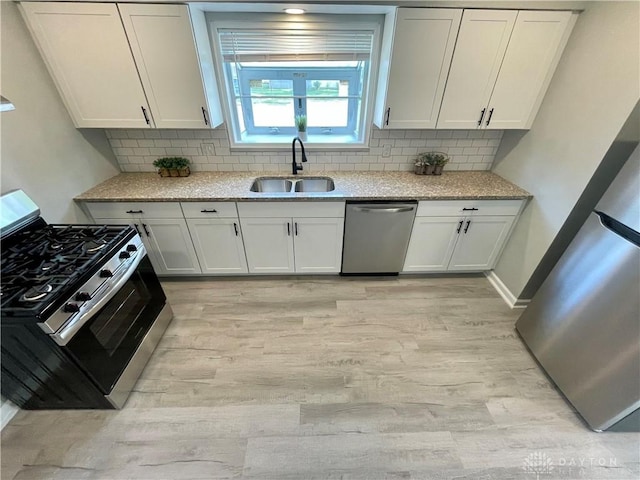 1601 Forrer Blvd, Kettering, OH 45420 - kitchen with stainless steel appliances, light wood-style floors, light stone counters, white cabinetry, and tasteful backsplash