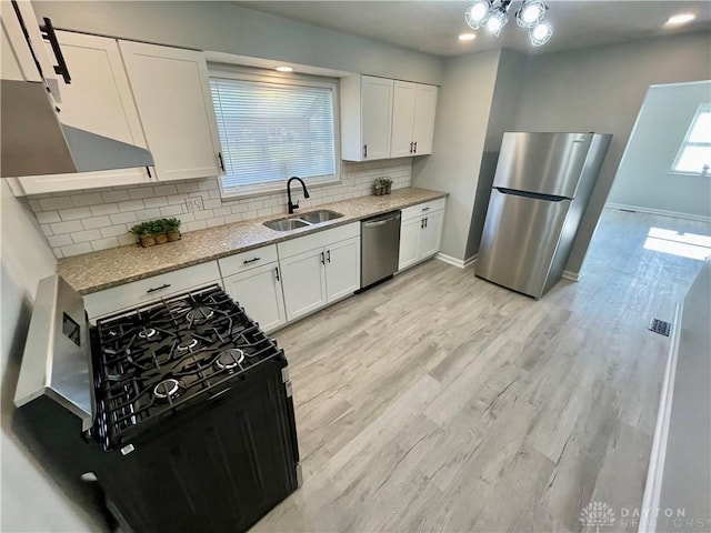 1601 Forrer Blvd, Kettering, OH 45420 - kitchen with appliances with stainless steel finishes, white cabinetry, tasteful backsplash, and wall chimney exhaust hood