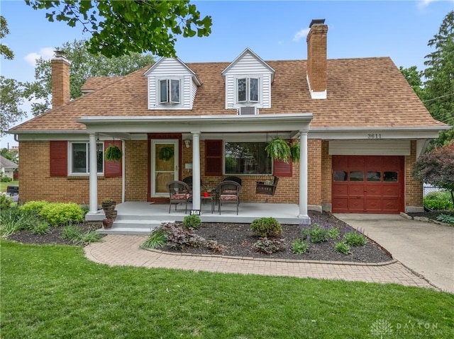 3611 Delaine Ave, Kettering, OH 45429 - cape cod house featuring a porch, a chimney, a garage, and brick siding