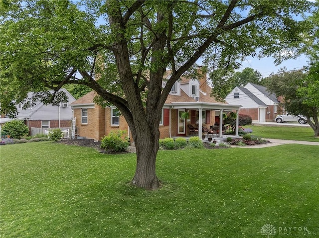 3611 Delaine Ave, Kettering, OH 45429 - traditional-style home with brick siding, a front yard, and a porch
