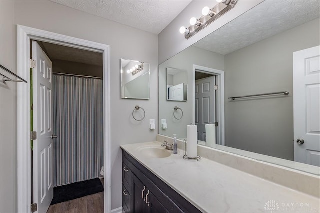 1107 Sunset Dr, Englewood, OH 45322 - full bath with vanity, wood finished floors, a textured ceiling, and curtained shower
