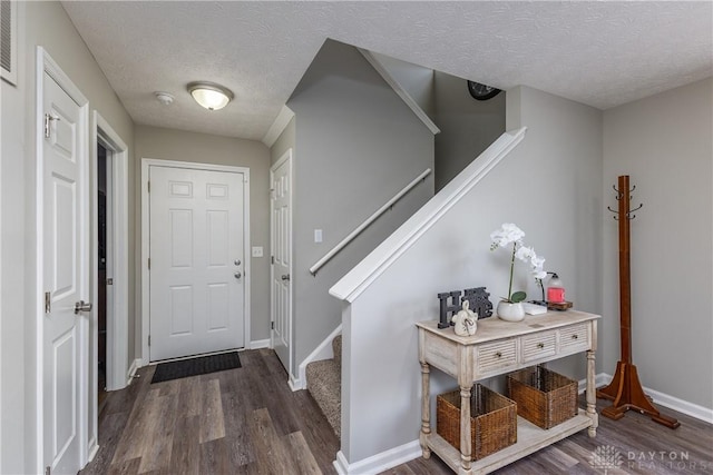 1107 Sunset Dr, Englewood, OH 45322 - entrance foyer with dark wood-style floors, a textured ceiling, and stairway