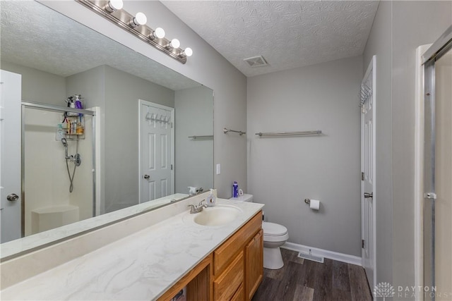 1107 Sunset Dr, Englewood, OH 45322 - full bathroom with wood finished floors, a shower stall, vanity, and a textured ceiling