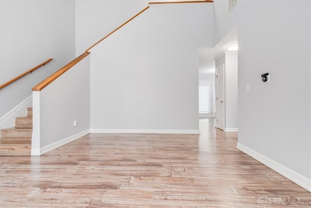 113 Village Trail Dr Unit 6, Vandalia, OH 45377 - unfurnished living room with a towering ceiling, wood finished floors, and stairway