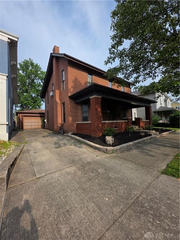 126 S Maple St, Eaton, OH 45320 - view of front of home with brick siding, a chimney, and an outbuilding