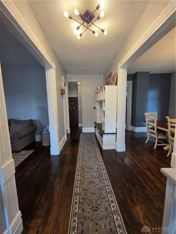 126 S Maple St, Eaton, OH 45320 - hallway featuring a textured ceiling, wood finished floors, and a chandelier