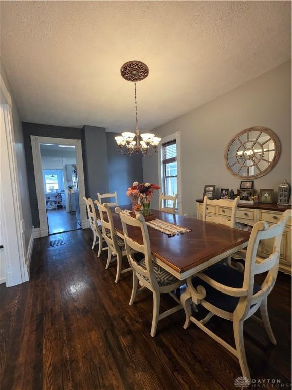 126 S Maple St, Eaton, OH 45320 - dining room featuring dark wood finished floors, a chandelier, and a textured ceiling