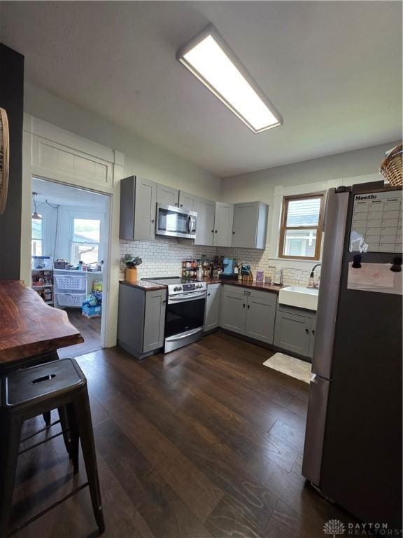 126 S Maple St, Eaton, OH 45320 - kitchen featuring appliances with stainless steel finishes, gray cabinets, healthy amount of natural light, and tasteful backsplash