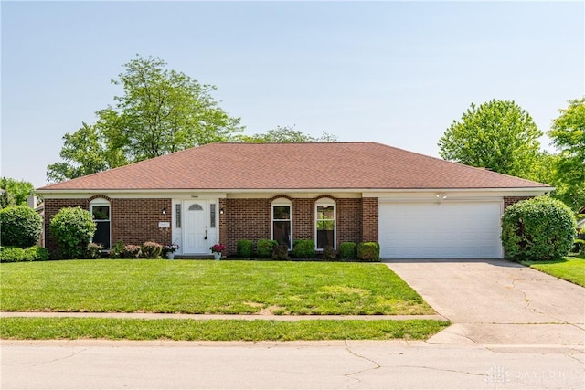 7044 Park Vista Rd, Englewood, OH 45322 - ranch-style house featuring driveway, an attached garage, a front lawn, and brick siding