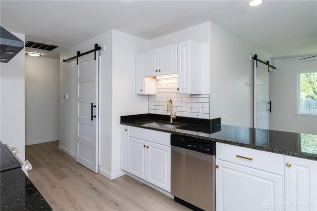 7044 Park Vista Rd, Englewood, OH 45322 - kitchen with a barn door, stainless steel dishwasher, white cabinets, light wood-style flooring, and dark stone countertops