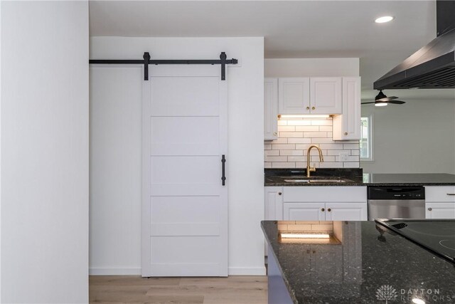 7044 Park Vista Rd, Englewood, OH 45322 - kitchen with ventilation hood, stainless steel dishwasher, dark stone countertops, light wood finished floors, and recessed lighting