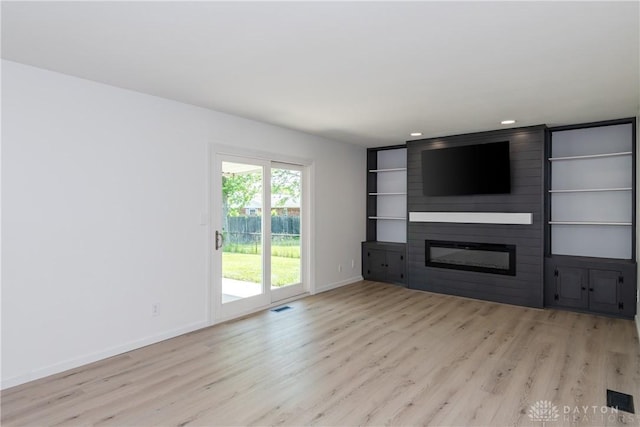 7044 Park Vista Rd, Englewood, OH 45322 - unfurnished living room with wood finished floors, a large fireplace, built in shelves, and recessed lighting