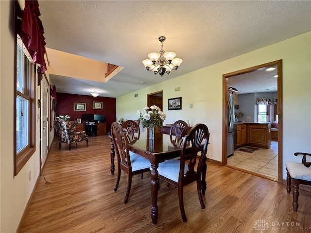 2950 S Clayton Rd, Farmersville, OH 45325 - dining area with a chandelier, light wood-style floors, a textured ceiling, and an office area