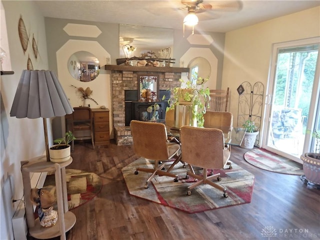291 Chamberlin Rd, Carlisle, OH 45005 - dining area with wood finished floors, a ceiling fan, and a stone fireplace