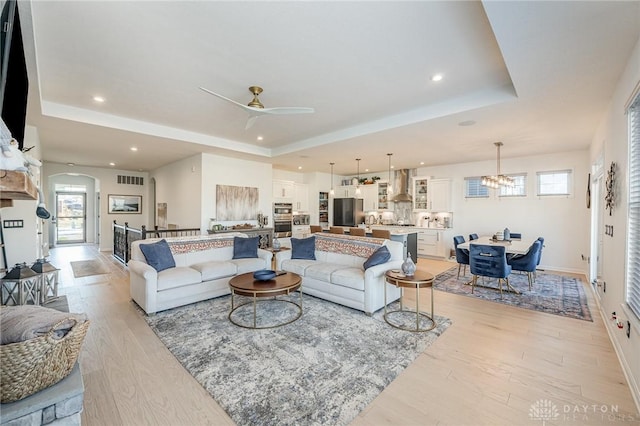 5078 Magellan Way, Franklin, OH 45005 - living area with a tray ceiling, light wood-style floors, recessed lighting, ceiling fan, and a chandelier