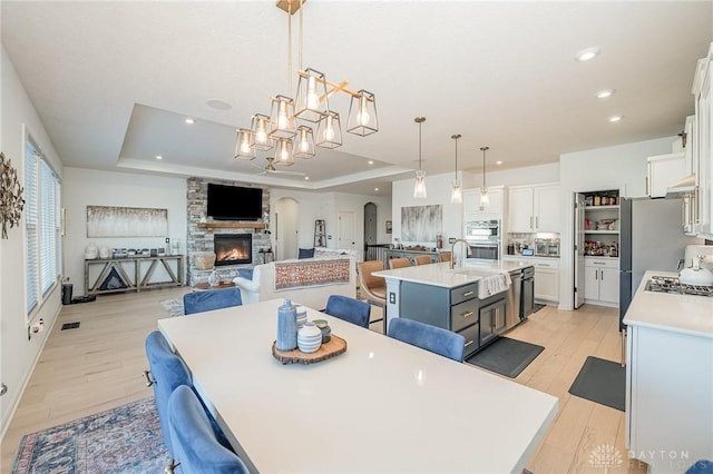 5078 Magellan Way, Franklin, OH 45005 - dining room with a raised ceiling, arched walkways, light wood-style floors, and recessed lighting