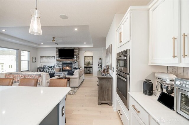5078 Magellan Way, Franklin, OH 45005 - kitchen featuring a tray ceiling, stainless steel double oven, light wood finished floors, recessed lighting, and white cabinets