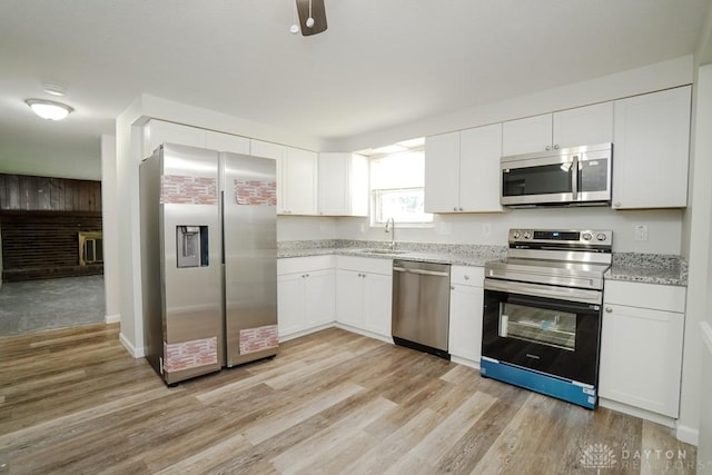 2949 N Bend Rd, Cincinnati, OH 45239 - kitchen featuring appliances with stainless steel finishes, light wood-style floors, white cabinets, and light stone countertops