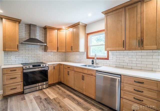 235 Stonequarry Rd, Vandalia, OH 45377 - kitchen with appliances with stainless steel finishes, wall chimney range hood, light wood finished floors, light countertops, and decorative backsplash