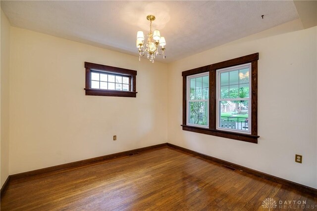 301 E Peach Orchard Ave, Oakwood, OH 45419 - spare room featuring dark wood-style floors and a chandelier