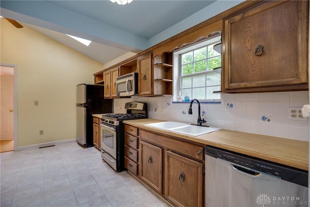 301 E Peach Orchard Ave, Oakwood, OH 45419 - kitchen featuring appliances with stainless steel finishes, lofted ceiling, decorative backsplash, open shelves, and a skylight