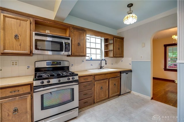 301 E Peach Orchard Ave, Oakwood, OH 45419 - kitchen with stainless steel appliances, open shelves, arched walkways, brown cabinetry, and decorative backsplash