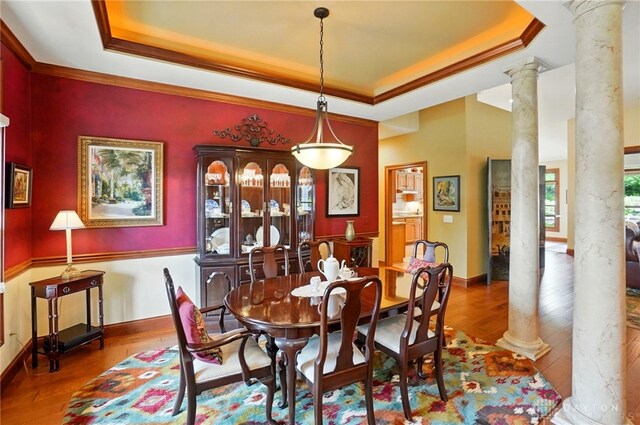 1106 Roger Scott Dr, Bellbrook, OH 45305 - dining area with ornate columns, a tray ceiling, wood-type flooring, and crown molding