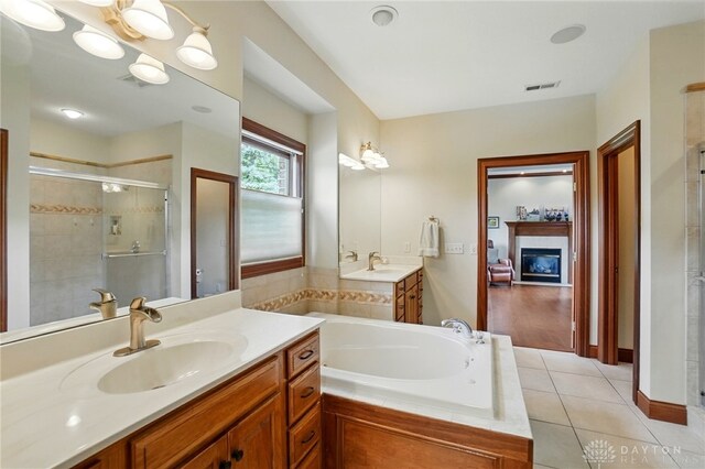 1106 Roger Scott Dr, Bellbrook, OH 45305 - full bath featuring vanity, a stall shower, a bath, a glass covered fireplace, and tile patterned floors