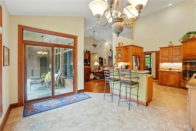 1106 Roger Scott Dr, Bellbrook, OH 45305 - kitchen featuring stainless steel appliances, a chandelier, a breakfast bar area, brown cabinets, and lofted ceiling