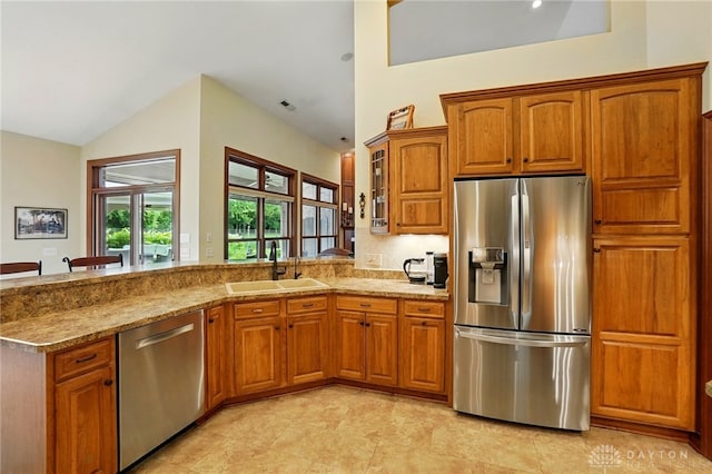 1106 Roger Scott Dr, Bellbrook, OH 45305 - kitchen featuring stainless steel appliances, brown cabinets, lofted ceiling, a peninsula, and glass insert cabinets