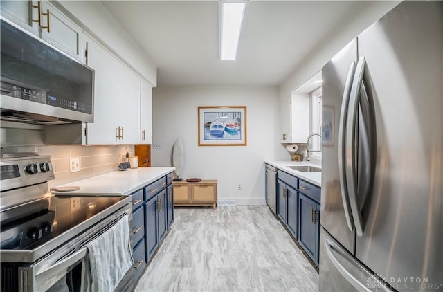 2435 S County Road 25a, Troy, OH 45373 - kitchen with stainless steel appliances, blue cabinets, decorative backsplash, and light countertops
