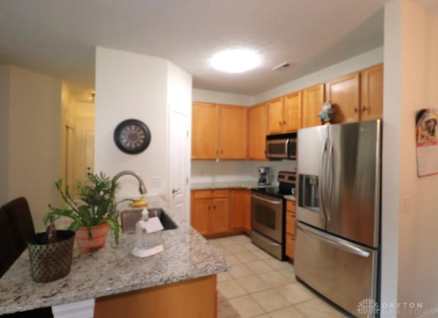 3224 Grand Falls Blvd, Maineville, OH 45039 - kitchen featuring appliances with stainless steel finishes, a peninsula, light brown cabinets, and light stone countertops