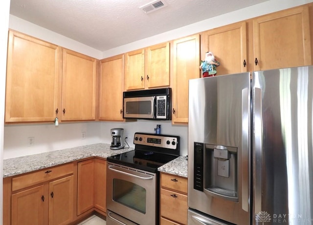 3224 Grand Falls Blvd, Maineville, OH 45039 - kitchen with stainless steel appliances, light stone countertops, and light brown cabinets